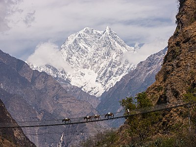 Nilgiri South (6,839m) forms an impressive backdrop to a large suspension bridge over the Kali Gandaki river near Tatopani.