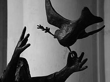 foto: detalje af en statue, der viser Noahs hænder, der frigiver due