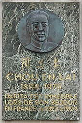Fotografie a unei plăci de marmură care poartă în partea de sus un bust sculptat pe un medalion metalic, în centru trei sinograme și în partea de jos următorul text: „Chou En Laï 1898-1976 a trăit în această clădire în timpul șederii sale în Franța din 1922 până în 1924 ".
