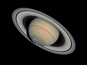 Colour photo of Saturn with overlaid false-colour image of ultraviolet polar aurora