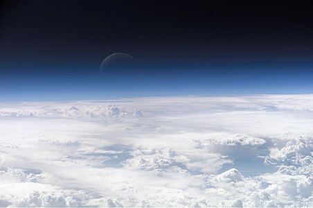 View of the crescent moon through the top of the earth's atmosphere. By International Space Station crew Expedition 13 over the South China Sea.