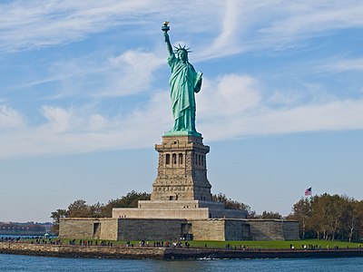 Statue of Liberty (more formally, Liberty Enlightening the World, and more colloquially, Lady Liberty) is a structure located on Liberty Island in New York Harbor, presented to the United States on the centennial of the signing of the American Declaration of Independence as a gift from France. It was designed by Frédéric Bartholdi and gets its green coloring from patination of the outer copper covering. The statue is world-renowned for being the first thing sea-borne visitors, immigrants, and returning Americans see upon entering New York Harbor and has been known as a beacon of freedom to much of the world. It earned UNESCO World Heritage Site status in 1984.